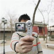 person holding video camera towards photograper